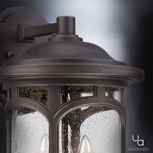 Here’s a rewritten sentence using your product data: Close-up of the Urban Ambiance UQL1105 Rustic Outdoor Wall Light from the Sydney Collection, measuring 17.75 inches high by 11 inches wide, showcasing a marine-grade Parisian Bronze finish with a dark metal frame and clear seeded glass panels that feature a subtle rain drop effect.