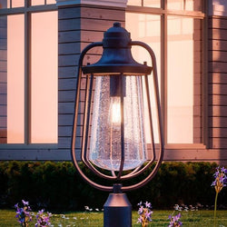 An Urban Ambiance UQL1124 Vintage Outdoor Post Light, a unique lighting fixture, from the San Francisco Collection creates a gorgeous ambiance in front of a house with its Estate Bronze Finish.