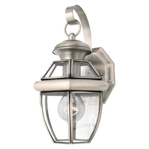 A beautiful Urban Ambiance UQL1141 Colonial Outdoor Wall Light fixture with a clear glass shade.