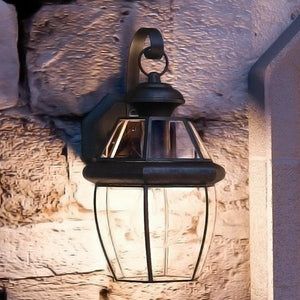 A beautiful Urban Ambiance Colonial Outdoor Wall Light on a stone wall.