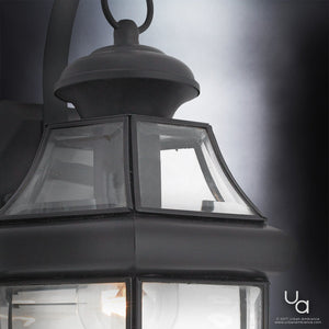 Close-up view of the Urban Ambiance UQL1142 Colonial Outdoor Wall Light from the Cambridge Collection, showcasing a 14-inch high by 8-inch wide black silk finish wall lantern with clear beveled glass panels and a visible light bulb inside.