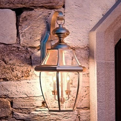 Unique Colonial Outdoor Wall Light with an Aged Silver Finish on a stone wall.