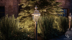 Outdoor lighting at night in front of a unique stone house with the UQL1151 Colonial Outdoor Post Light, 23
