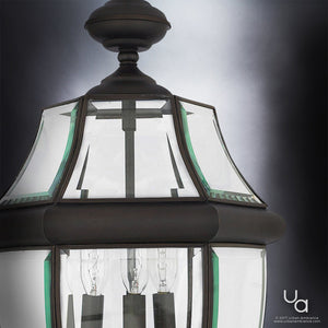 Close-up of the Urban Ambiance UQL1159 Colonial Outdoor Pendant Light from the Cambridge Collection, featuring a black silk finish, clear beveled glass panels, and visible bulbs inside, set against a gradient gray background.