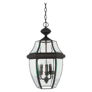 The Urban Ambiance UQL1159 Colonial Outdoor Pendant Light from the Cambridge Collection features a black silk finish with beveled glass and three candle-style bulbs, elegantly suspended by a chain. This 21-inch high, 12.5-inch wide pendant combines durability with sophisticated style, making it an ideal choice for illuminating patios or entryways.
