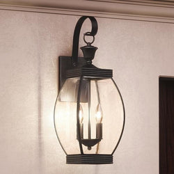 An Urban Ambiance UQL1171 Colonial Outdoor Wall Light with a unique clear glass shade.