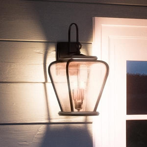 A unique French Country outdoor wall lamp from the Florence Collection, boasting a gorgeous black silk finish, mounted on a house's exterior wall.