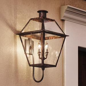 A beautiful Urban Ambiance UQL1212 Historic Outdoor Wall Light, 29"H x 13.5"W, Rustic Copper Finish, Paris Collection hanging on a wall next to a door.