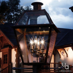 A beautiful lighting fixture with four UQL1213 Historic Outdoor Post Lights, 26"H x 17"W, Rustic Copper Finish, Paris Collection on it in front of a house.