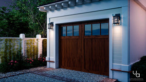 A single-car garage with wooden double doors, two Urban Ambiance Zurich UQL1230 Craftsman Outdoor Wall Lights in black silk finish, white exterior siding, and a gravel driveway.