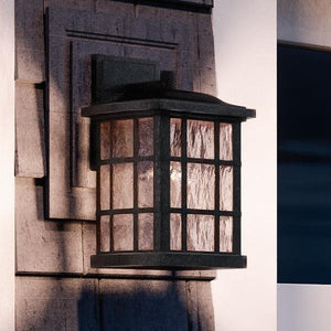 A unique UQL1232 Craftsman Outdoor Wall Light from the Zurich Collection by Urban Ambiance, 13"H x 8"W, with a black silk finish, on the side of