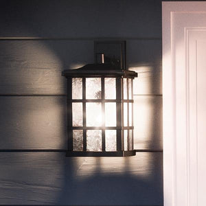 A luxurious UQL1234 Craftsman Outdoor Wall Light, with a gorgeous black silk finish, from the Zurich Collection by Urban Ambiance, enhancing the entrance next to a door.