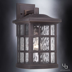 The Urban Ambiance UQL1235 Craftsman Outdoor Wall Light from the Zurich Collection features a Parisian Bronze finish, clear textured glass panels, and a square backplate. Measuring 15.5″H x 9.5″W, this weather-resistant, marine-grade fixture is illuminated by a single bulb.
