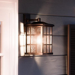 An Urban Ambiance UQL1237 Craftsman Outdoor Wall Light, 17"H x 11"W, Parisian Bronze Finish, Zurich Collection providing luxury lighting on the side of a house.