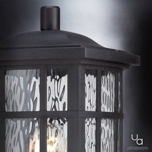 Close-up of the Urban Ambiance UQL1246 Craftsman Outdoor Post Light from the Zurich Collection, featuring marine-grade construction, textured glass, and a black silk finish, illuminated against a blurred gray background.