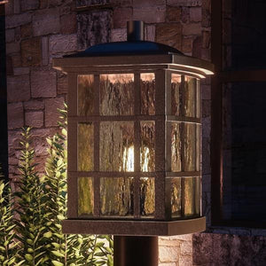 An Urban Ambiance Zurich Collection UQL1247 Craftsman Outdoor Post Light with a glass lantern on it, creating a unique and beautiful ambiance