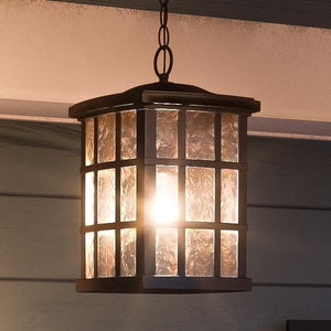 A beautiful UQL1251 Craftsman Outdoor Pendant Light, hanging from a wall in a Parisian Bronze Finish.