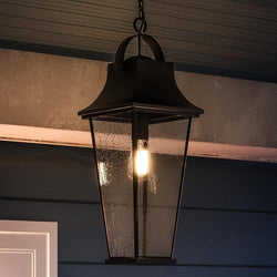 A beautiful Tudor Outdoor Pendant Light, 24"H x 8.75"W, from the Constanta Collection hanging on a porch.