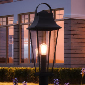 A unique UQL1284 Tudor Outdoor Post/Pier Light illuminating a house at dusk.