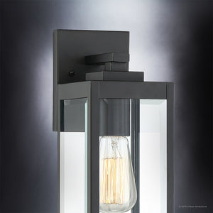 Close-up of the Urban Ambiance UQL1330 Farmhouse Outdoor Wall Light from the Quincy Collection, showcasing its 14.25″H x 5″W dimensions, black finish, beveled glass panels, and an exposed Edison-style bulb mounted on a square backplate against a neutral background.