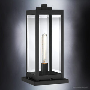 The UQL1336 Modern Farmhouse Outdoor Pier Light from Urban Ambiance’s Quincy Collection features a rectangular design in a natural black finish, clear glass panels, and a visible tubular bulb set against a gradient gray background—an ideal choice for those seeking pier lighting with timeless, modern farmhouse appeal.