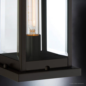 Close-up of the Urban Ambiance UQL1355 Modern Farmhouse Outdoor Pier Light from the Quincy Collection, featuring a visible exposed bulb within black metal and beveled glass panels, finished in Estate Bronze and measuring 16 inches high by 7.5 inches wide.
