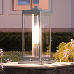 An Urban Ambiance lighting fixture on a stone wall in front of a house.