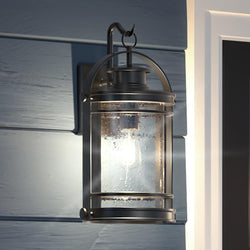 An Urban Ambiance UQL1432 Nautical Outdoor Wall Light, 18.25"H x 10.75"W, Black Silk Finish, Cannes Collection lamp hanging on the side of a house