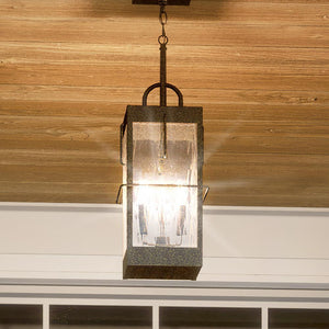 A beautiful UQL1465 Ultilitarian Outdoor Pendant Light, made by Urban Ambiance, is hanging from the ceiling of a porch.