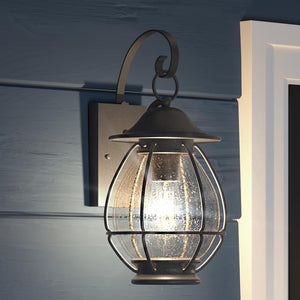 A unique Craftsman Outdoor Wall Light, 17"H x 8.5"W, in a luxury Black Sand Finish from the Hammond Collection on a wall outside of a house.