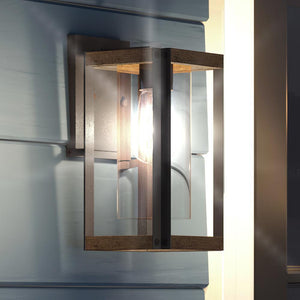 A beautiful and unique lighting fixture, the UQL1502 Modern Outdoor Wall Light from the Suffolk Collection by Urban Ambiance is installed on the side of a house.