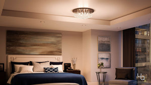 Modern bedroom with a large bed, abstract wall art, side tables, a chair, and the Urban Ambiance Manhattan Collection UQL2081 Traditional Flush Mount Ceiling Light (9″H x 19.75″W) in a sleek chrome finish overhead, with city views through expansive windows.
