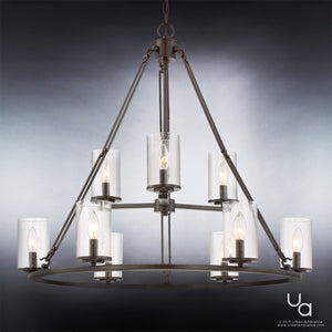The UQL2131 Industrial Chandelier from the Valencia Collection by Urban Ambiance features an estate bronze finish and eight candle-shaped bulbs, each nestled in a clear cylindrical glass shade, elegantly suspended by a chain against a gradient gray background.