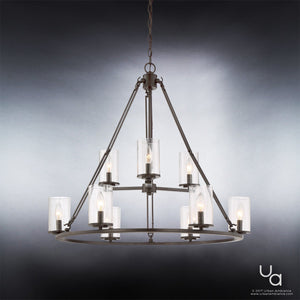 The Urban Ambiance UQL2131 Industrial Chandelier from the Valencia Collection, featuring eight candle-style lights in seeded glass shades and a refined Estate Bronze finish, hangs from a chain against a gradient gray background.