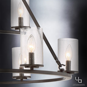 Close-up of the Urban Ambiance UQL2131 Industrial Chandelier from the Valencia Collection, featuring an Estate Bronze finish with cylindrical, seeded glass shades and lit candle-style bulbs, set against a gradient background.