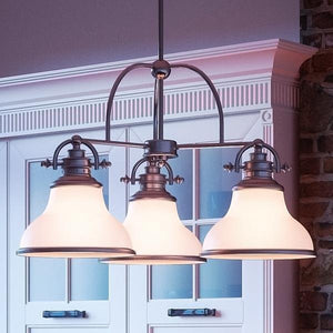 Three unique UQL2330 Industrial Chandeliers, 15.5"H x 24"W, Brushed Nickel Finish from the Pasadena Collection by Urban Ambiance hanging over a kitchen island.