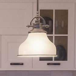 A kitchen with white cabinets and an Urban Ambiance UQL2336 Industrial Pendant Light, 9.5"H x 8"W, Brushed Nickel Finish from the luxury Pasadena Collection.