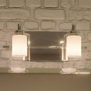 A gorgeous Urban Ambiance bathroom vanity with two UQL2401 Modern Bathroom Vanity Lights for beautiful lighting, Polished Chrome Finish from the Napa Collection, and a brick wall.