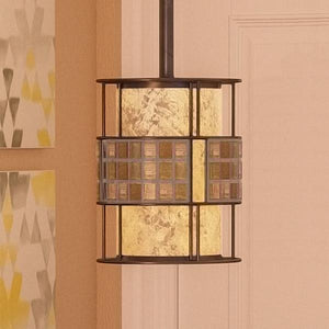 A beautiful pendant light from the Genoa Collection, with a Copper Revival finish, hanging on the wall.