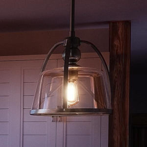 A beautiful UQL2640 Vintage Pendant Light with a glass shade hanging in a kitchen.