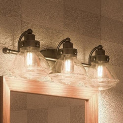 A gorgeous Urban Ambiance Brookline Collection UQL2652 Transitional Bathroom Vanity Light, 8"H x 25"W, Bronze Finish with three lights and a mirror.