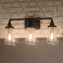 Three beautiful UQL2662 luxury lighting fixtures, 11"H x 21.5"W, Antique Black Finish from Urban Ambiance hanging on a brick wall.