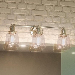 A beautiful bathroom with an Urban Ambiance UQL2681 Industrial Chic Bathroom Vanity Light, 9"H x 23"W, Polished Nickel Finish from the Philadelphia Collection above a brick wall.