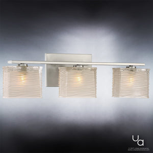 The Urban Ambiance UQL2722 Modern Bathroom Light from the San Diego Collection showcases three wavy glass shades and a sleek brushed nickel backplate, elegantly mounted on a gray wall.