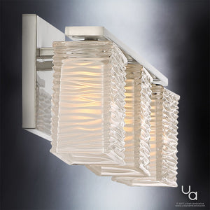 The Urban Ambiance UQL2722 Modern Bathroom Light from the San Diego Collection features three wavy glass shades on a brushed nickel base, each illuminated with a soft, warm glow. With its textured glass and sleek metallic finish, this 6.75″H x 22.5″W wall sconce brings an elegant yet contemporary touch to any space.