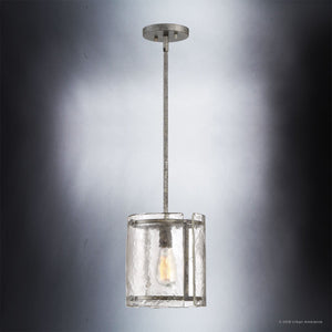 The UQL2871 Industrial Pendant from Urban Ambiance’s Nantes Collection features a sleek cylindrical water-glass shade and a silver etch metal frame, suspended from the ceiling by a straight rod against a gradient backdrop—perfect for adding an industrial accent to contemporary or rustic kitchen lighting designs.