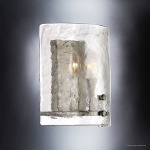 The UQL2873 Industrial Wall Sconce from the Nantes Collection by Urban Ambiance features a textured glass shade in a striking Silver Etch finish, and is softly illuminated by two visible bulbs—bringing an element of rustic lighting to any space. Measuring 10″H x 8.75″W, this modern wall sconce beautifully combines industrial style with contemporary elegance.