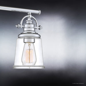 The Urban Ambiance UQL2881 Industrial Bathroom Vanity Light from the Salford Collection, featuring a polished chrome finish and clear glass shade, hangs from a horizontal rod against a gradient gray background, creating a striking industrial bath lighting effect.
