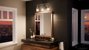 Contemporary bathroom featuring a wood-framed mirror, double sink with a black countertop, and expansive windows overlooking a city skyline at sunset. The space is illuminated by the Urban Ambiance UQL2881 Industrial Bathroom Vanity Light from the Salford Collection (9.5″H x 23″W, Polished Chrome Finish), along with sleek wall sconce fixtures for a modern industrial touch.