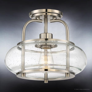The UQL3280 Utilitarian Ceiling Light from Urban Ambiance’s Clearwater Collection features a contemporary semi-flush mount design in a brushed nickel finish with a clear seeded glass shade and visible exposed bulb for added style; it measures 10″ high by 12″ wide.